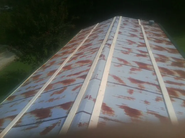 Rusted metal roof panels with new wood purlins before replacement — Storm Damage Roof Repair in Stow by Roofing Brothers