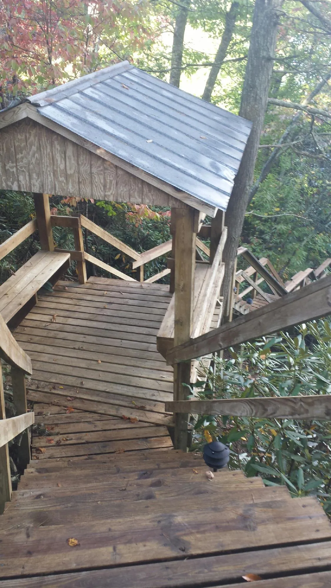 Metal roofed shelter over wooden steps on a wooded walkway — Skylight Repair & Installation work by our crew in Stow
